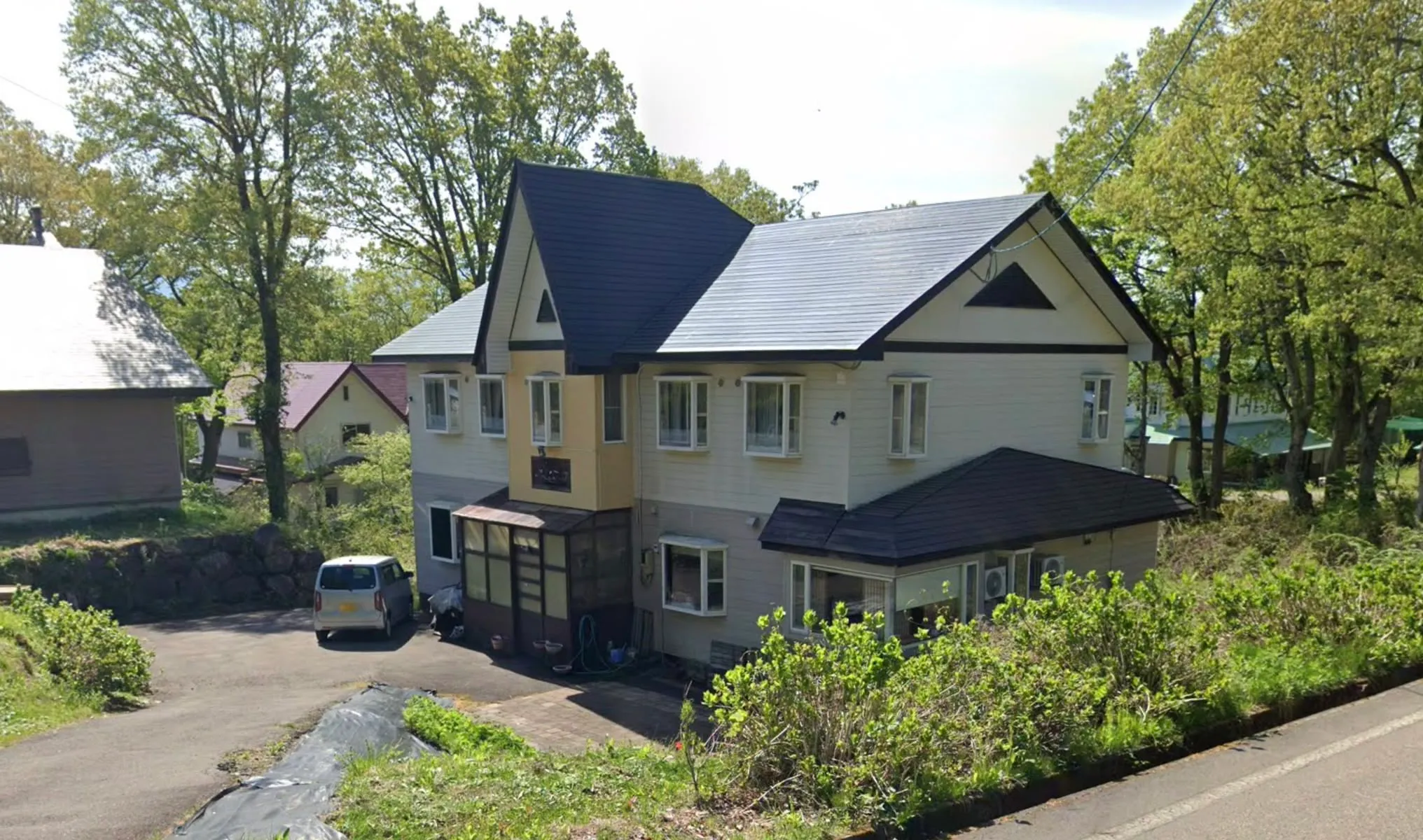 Glomec Lodge exterior in the snow-covered alpine forest of Myoko Kogen